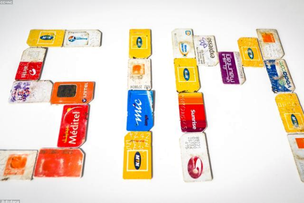 Téléphone et carte SIM sur table avec notes de budget